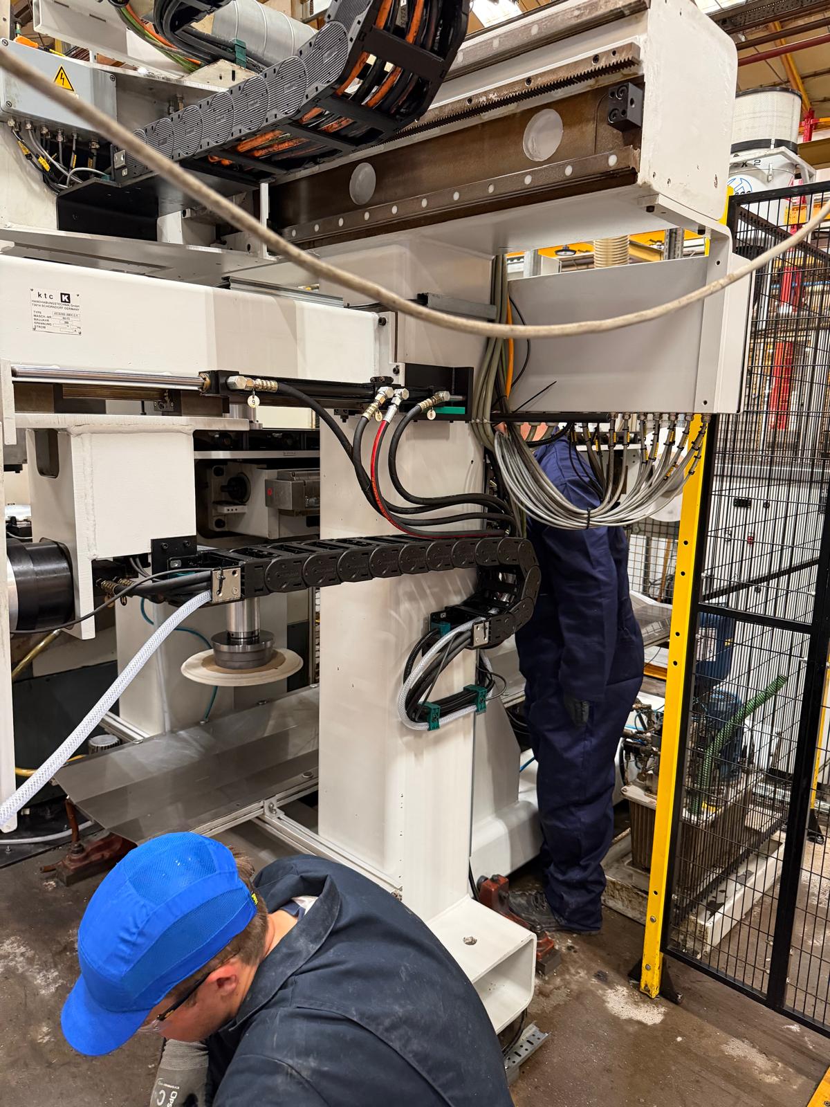Engineer working on machinery cabling and services within an industrial facility